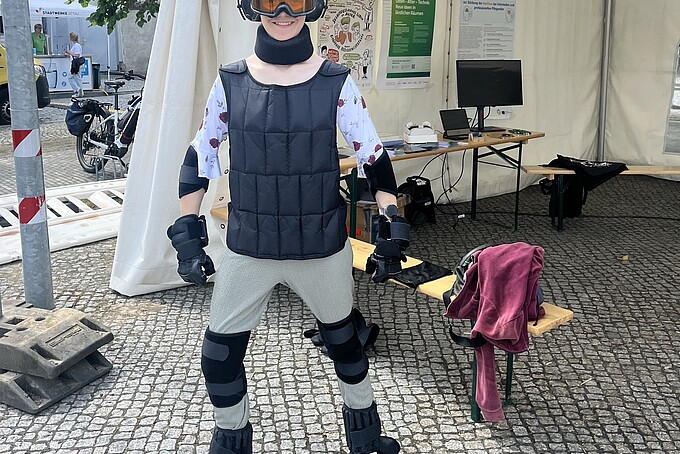 Besucherin im Alterssimulationsanzug