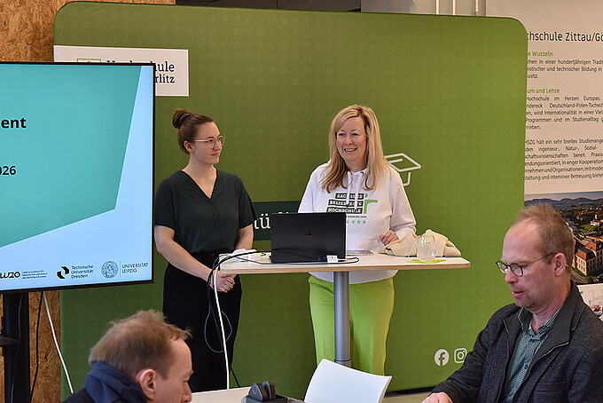 Prorektorin Prof. Dr. Sophia Keil steht beim Workshop Einführung in das Forschungsdatenmanagement vor einer grünen Pressewand und spricht zu den Teilnehmenden.
