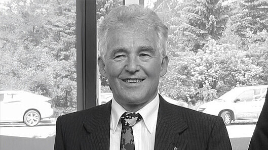 Prof. Hedrich im Anzug lächelt in die Kamera.