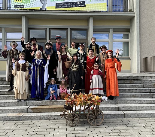 Gruppenfoto der Umzugteilnehmenden in mittelalterlichen Kostümenvor dem Haus ZI