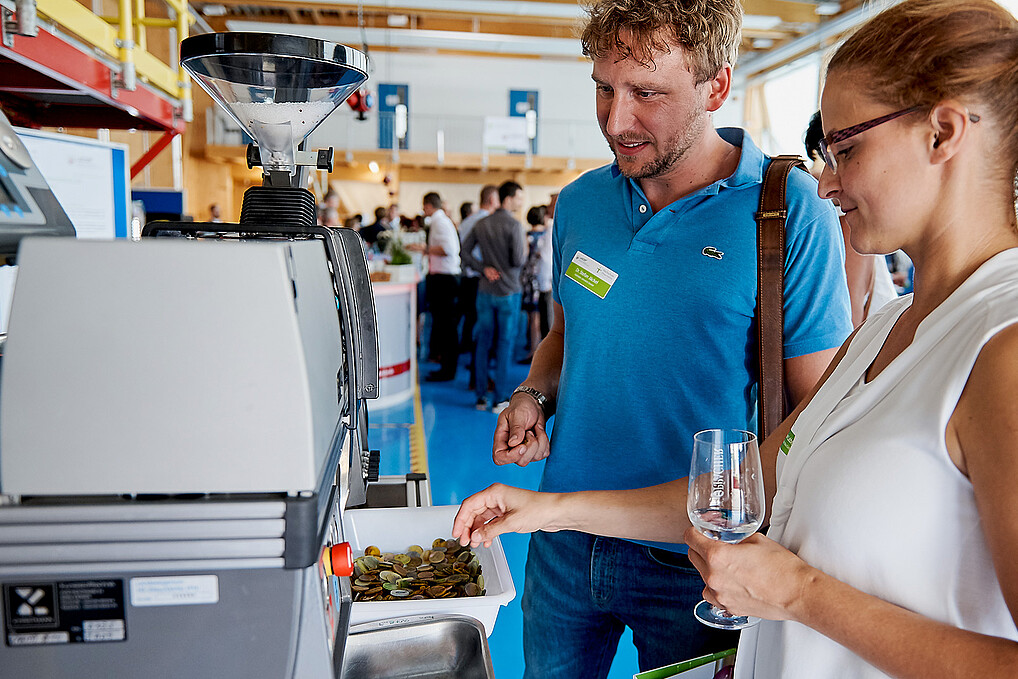 Ein Mann und eine Frau stehen vor einer technischen Anlage