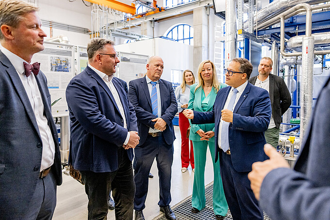 Dr. Andreas Handschuh und Christian Hartmann im Gespräch mit Vertreterinnen und Vertretern der Hochschule beim Rundgang durch das Zittauer Kraftwerkslabor und die Versuchsanlage AQVA-Heat.