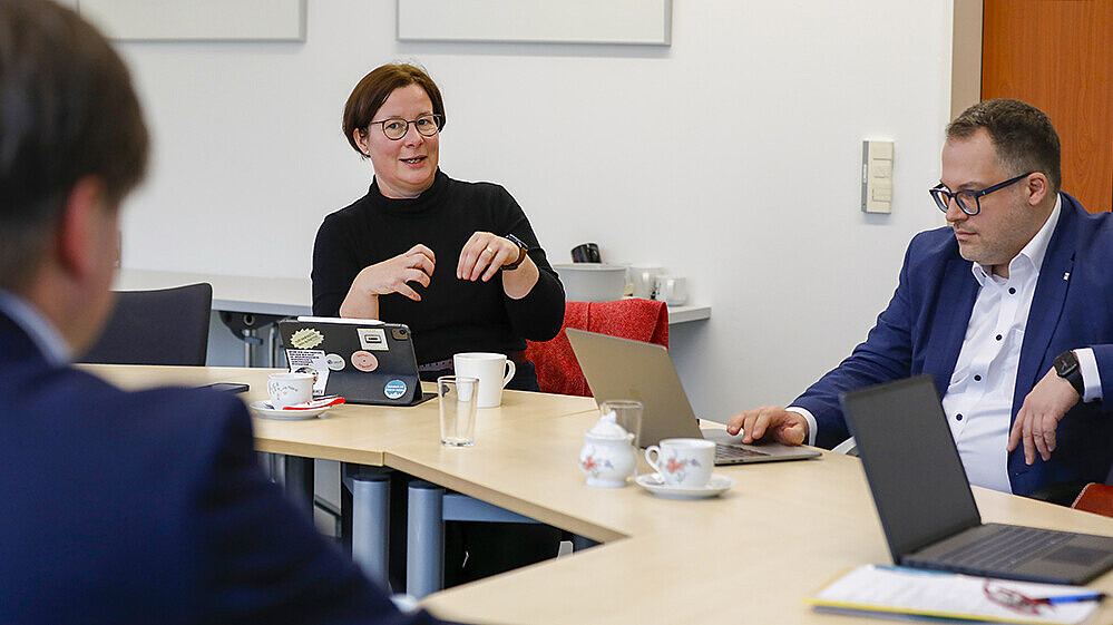 Eine Professorin unterhält sich am Tisch mit dem Rektor der HSZG.