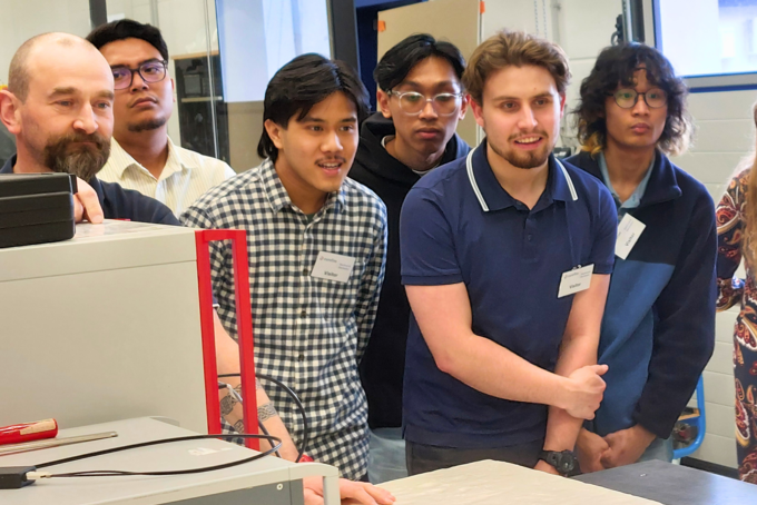 Mehrere Personen schauen jemanden über einen Tisch an